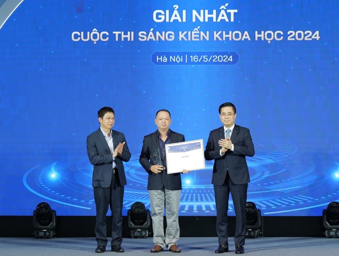 Thứ trưởng Khoa học và Công nghệ Nguyễn Hoàng Giang (bìa phái), ông Phạm Hiếu, Tổng biên tập báo VnExpress (bìa trái) trao cho giải nhất cho đại diện nhóm Biomass Lab Ảnh: Ngọc Thành