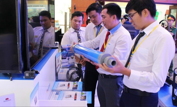 Kỹ sư Lê Trung Hiếu (giữa) giới thiệu sản phẩm xử lý cáu cặn trên ống nước ở một triển lãm tại TP HCM năm 2020. Ảnh: NVCC