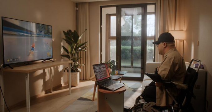 Bệnh nhân bị mất tứ chi đang chơi game đua xe bằng trí óc sau ca phẫu thuật cấy ghép thiết bị giao diện não-máy tính (BCI) vào não tại Thượng Hải. Ảnh: CEBSIT/CAS/Xinhua