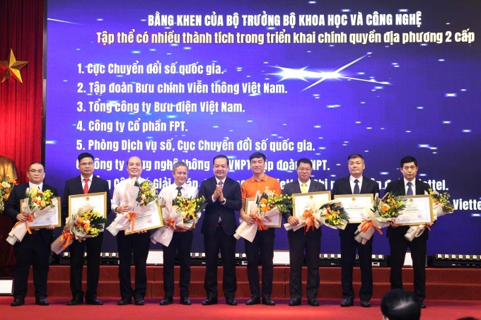 Thứ trưởng Phạm Đức Long (người thứ năm từ bên trái) trao bằng khen của Bộ trưởng Khoa học và Công nghệ cho các tập thể có nhiều thành tích trong triển khai chính quyền địa phương hai cấp. Ảnh: TTTT