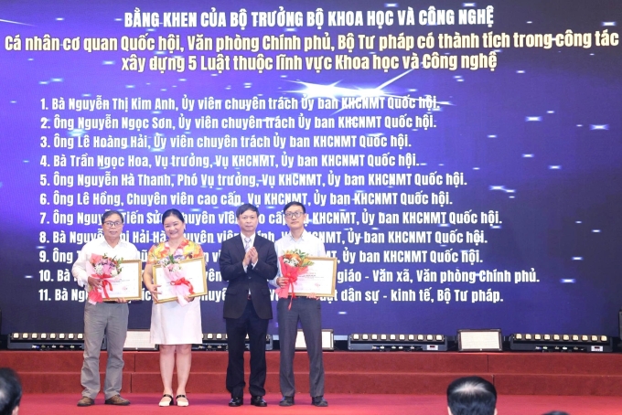 Thứ trưởng Phạm Đức Long (người thứ ba từ bên trái) trao bằng khen của Bộ trưởng Khoa học và Công nghệ cho các cá nhân có thành tích trong công tác xây dựng năm luật. Ảnh: TTTT