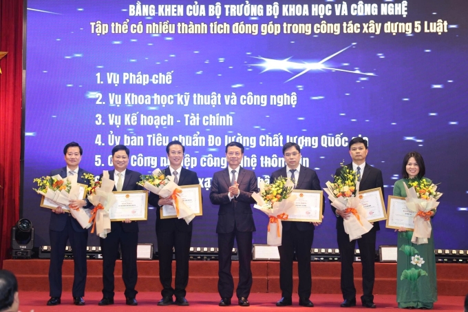 Bộ trưởng Nguyễn Mạnh Hùng (người thứ tư từ bên trái) trao bằng khen cho các tập thể có nhiều thành tích trong công tác xây dựng năm luật. Ảnh: TTTT